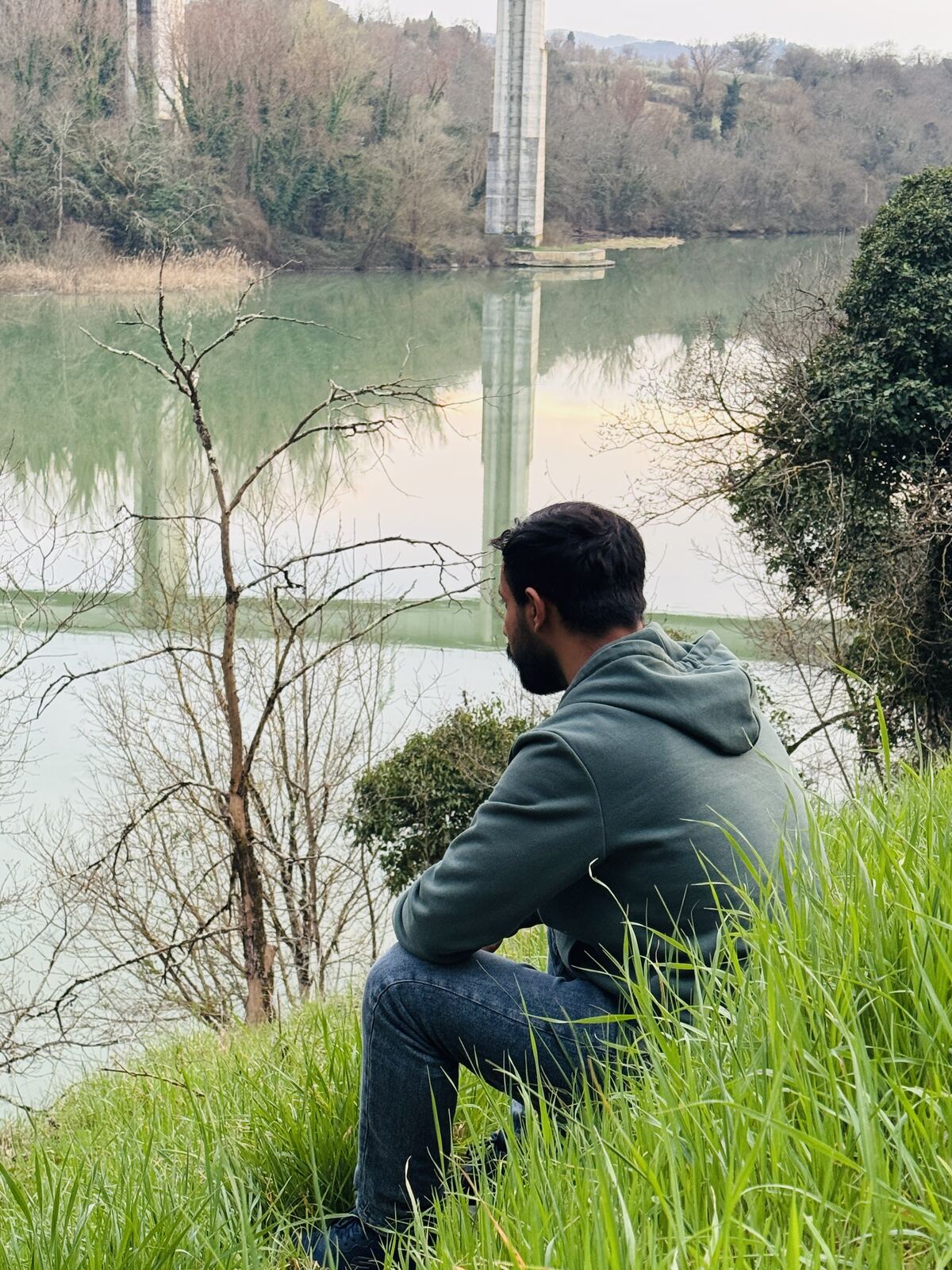 Mohammed sitting by a river in Italy